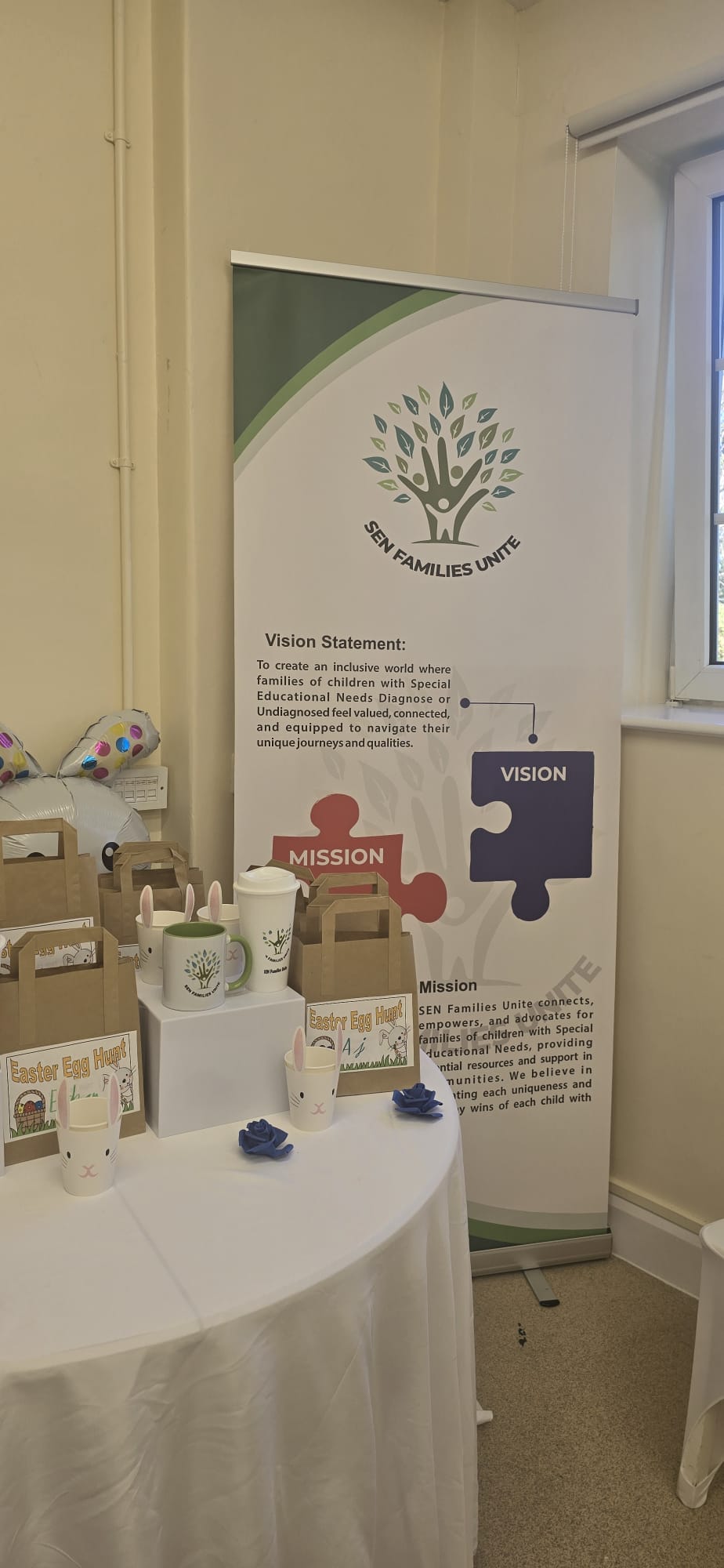 SEN Families Unite vision and mission banner displayed beside the Easter Egg Hunt table.